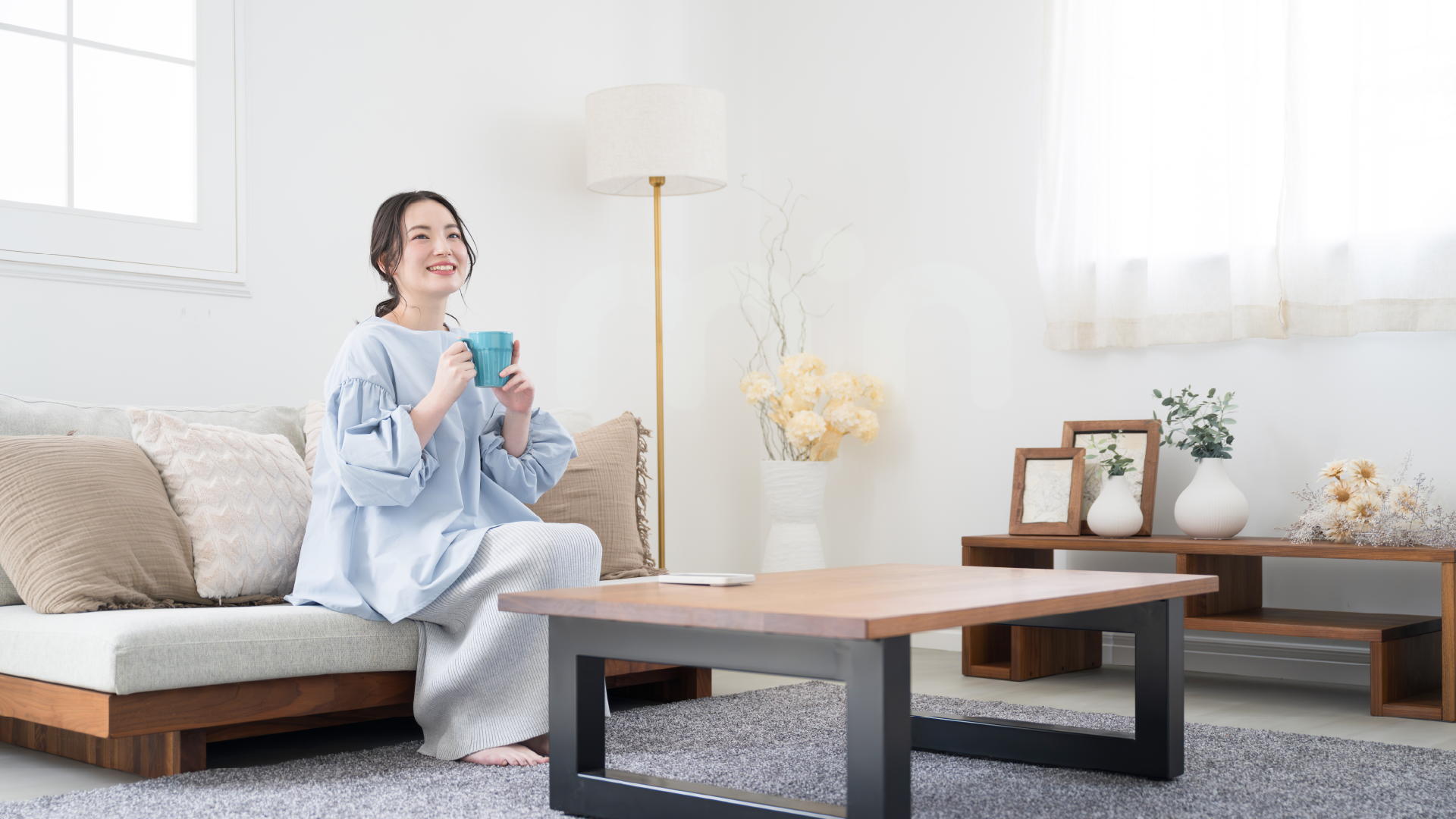 Lady enjoying a cup of tea in a minimalist living room